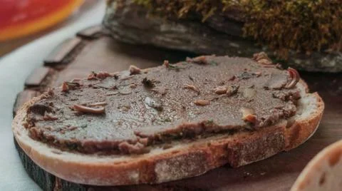 Thick slice of meat p?t? on bread with green herbs and drizzled oil Foto stock