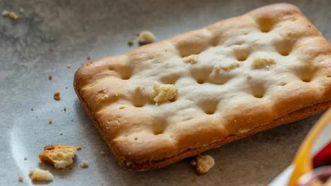 Thick slice of white bread with visible air pockets on a wooden surface Foto stock