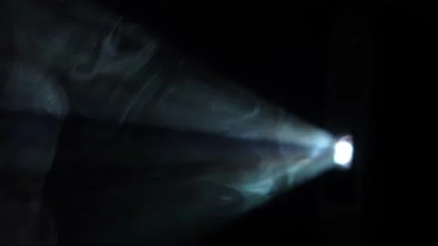 Thick smoke glows in the spotlight beams. A home movie projector shines on dense Stock Footage 195712138