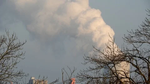 Thick smoke rises out of a chimney into the blue sky Stock Footage 106329612