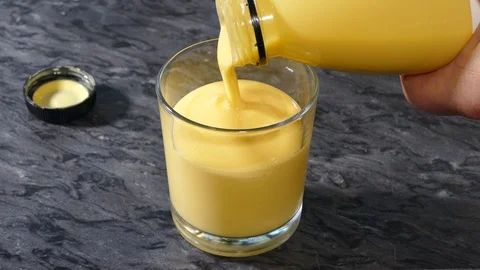 Thick, smooth, fruit yoghurt drink being poured into a glass tumbler. Stock-Footage 129161526