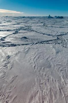 Thick snow-covered pack-ice and trapped icebergs, Antarctica Stock Photos