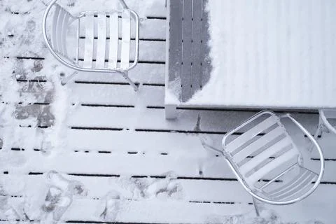 Thick snow covers a table and chairs outside a restaurant Stock Photos