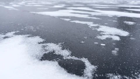 Thick solid layer of ice of frozen river with freeze bubbles Stock Photos