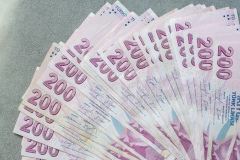 A thick stack of Turkish lira is laid out on a gray velvet table, ready to be Stock Photos