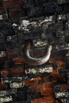 A thick, steel hook in the ceiling of a brick fortress. An old, rusty hook Stock Photos