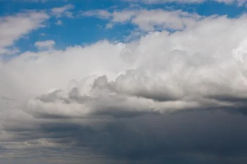Thick storm clouds stretch across the sky with a visible curtain of rain falling 스톡 사진