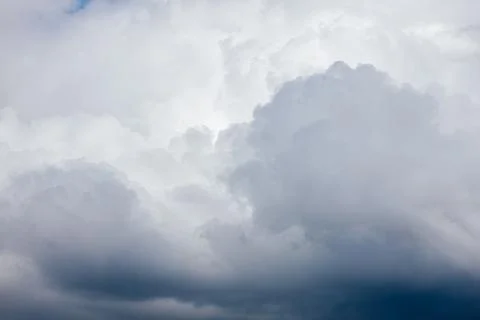 Thick storm clouds stretch across the sky with a visible curtain of rain falling 스톡 사진