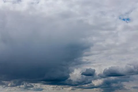 Thick storm clouds stretch across the sky with a visible curtain of rain falling Foto stock