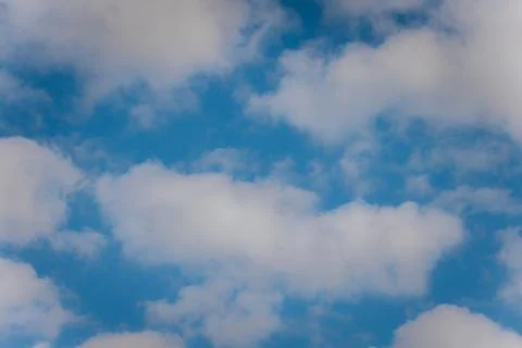 Thick storm clouds stretch across the sky with a visible curtain of rain falling Stock Photos