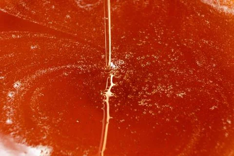 Thick stream of golden maple syrup pouring down Stock Photos