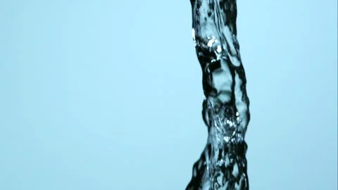 Thick twisted stream of clear water pouring down against ligh Video stock 326031152