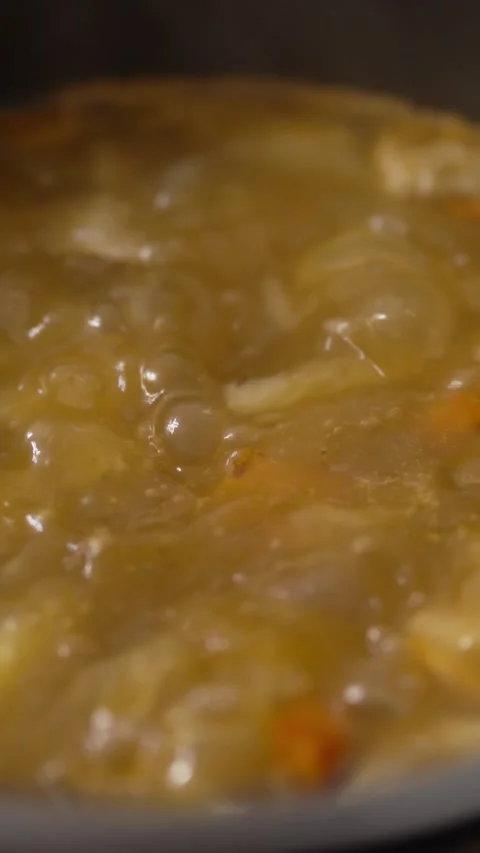 Thick vegetable stew in motion boiling with bubbles close up Stock Footage 333471879