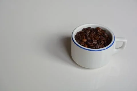 Thick-walled ceramic cup filled with coffee beans Stock Photos