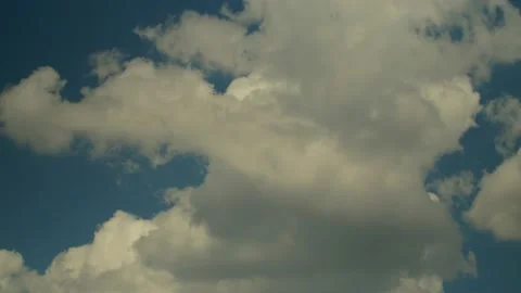 Thick white clouds float across the blue summer sky. Timelapse. Stock Footage 144139312