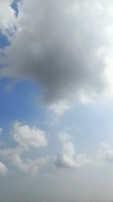 Thick white clouds with some of them turning grey floated in the blue sky. .. Stock Footage 338241373