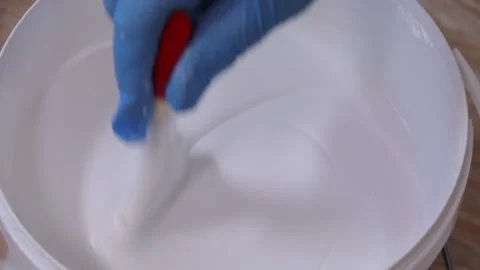 Thick white paint is being mixed with a brush Stock Footage 113788247