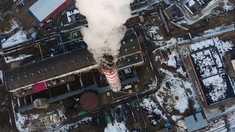 Thick white smoke coming from a red-white pipe in the industrial zone.  Video stock 102702934