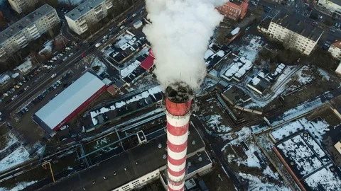 Thick white smoke coming from a red-white pipe in the industrial zone.  Video stock 102703125