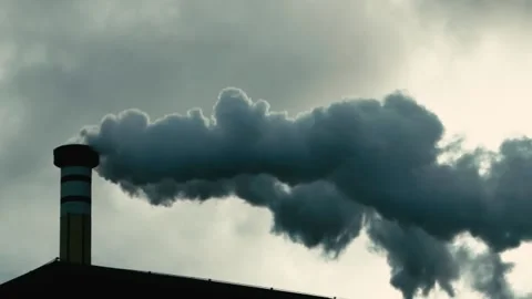 Thick white smoke emanates from a chimney against a gloomy dark sky. Air Stock Footage 168916130