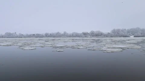Thick white snow-covered ice floes float along the wide Neman River Stock Footage 220186257