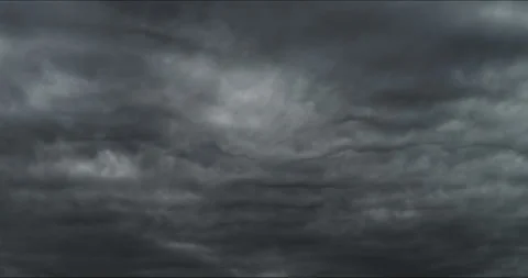 Thickening altocumulus undulatus clouds roll across the heavy gray sky. Stock Footage 339040749