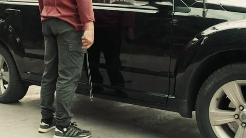 Thief with a crowbar next to someone's car Stock Footage 283066401