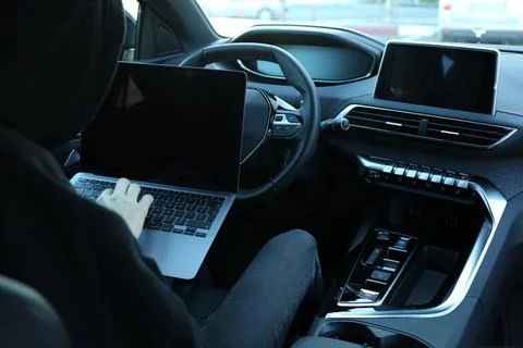 Thief hacking car system with laptop inside vehicle, closeup Stock Photos