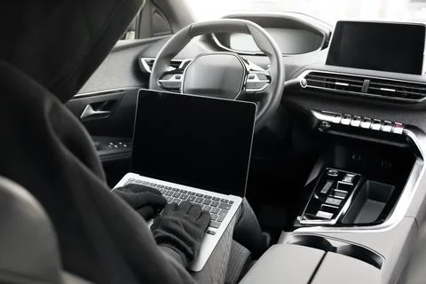Thief hacking car system with laptop inside vehicle, closeup Stock Photos