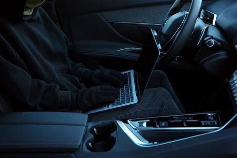 Thief hacking car system with laptop inside vehicle, closeup Stock Photos