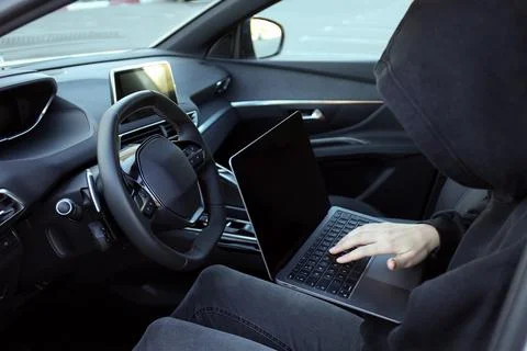 Thief hacking car system with laptop inside vehicle, closeup Stock Photos