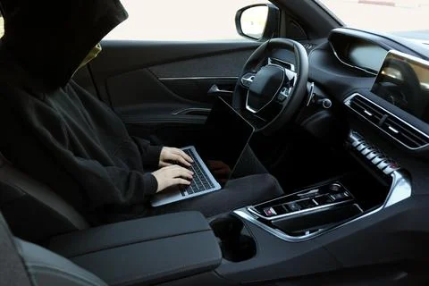 Thief hacking car system with laptop inside vehicle, closeup Stock Photos