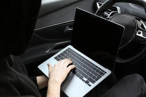 Thief hacking car system with laptop inside vehicle, closeup Stock Photos