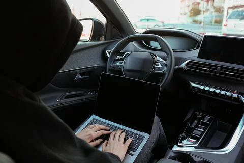 Thief hacking car system with laptop inside vehicle, closeup Stock Photos