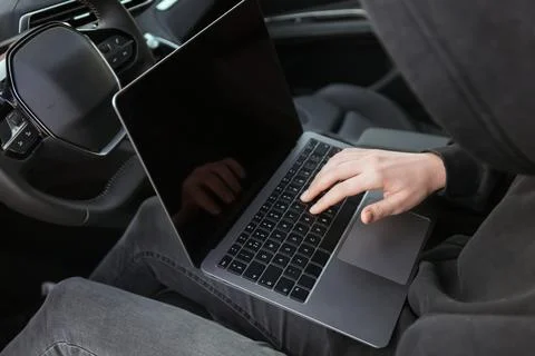 Thief hacking car system with laptop inside vehicle, closeup Stock Photos