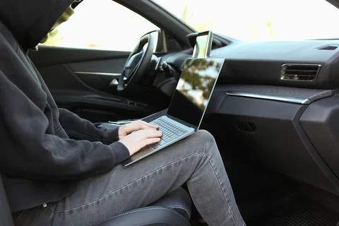Thief hacking car system with laptop inside vehicle, closeup Stock Photos