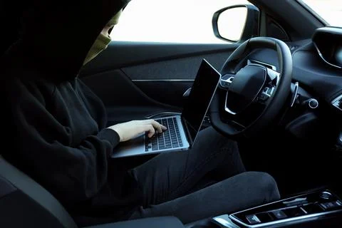 Thief hacking car system with laptop inside vehicle, closeup Stock Photos
