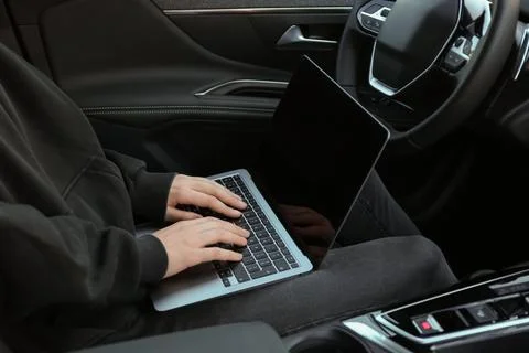 Thief hacking car system with laptop inside vehicle, closeup Stock Photos
