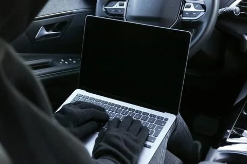 Thief hacking car system with laptop inside vehicle, closeup Stock Photos