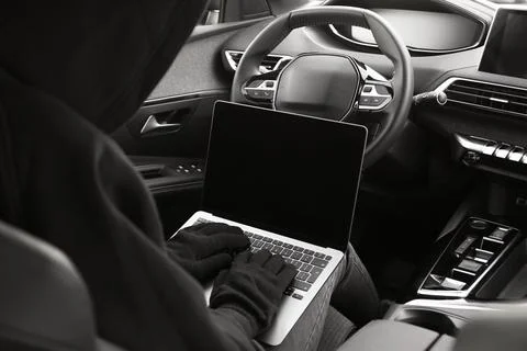Thief hacking car system with laptop inside vehicle, closeup Stock Photos