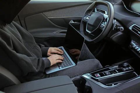 Thief hacking car system with laptop inside vehicle, closeup Stock Photos