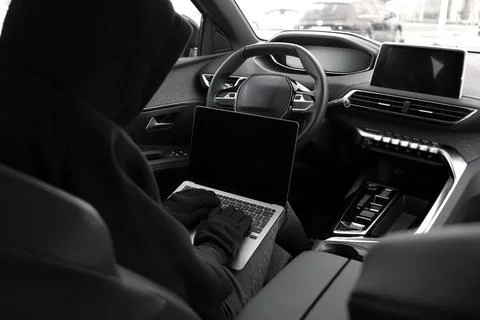 Thief hacking car system with laptop inside vehicle, closeup Stock Photos