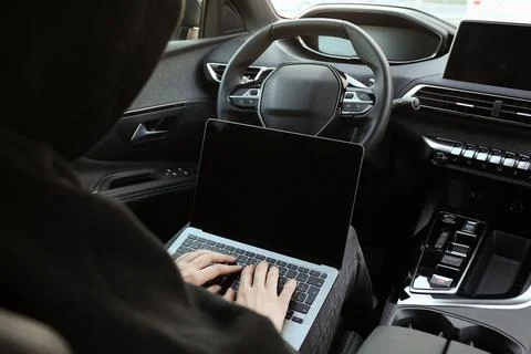 Thief hacking car system with laptop inside vehicle, closeup Stock Photos