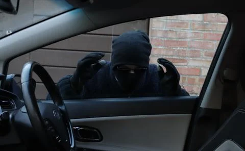 Thief looking in through a car window Stock Photos