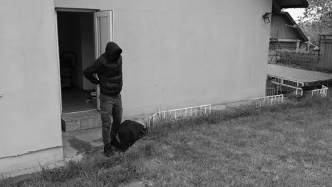 A thief or robber leaves the house with a bag of loot, captured on a CCTV camera Stock Footage 273849351