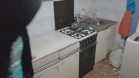 Thief rushing into kitchen and looking for things to steal, hidden camera video Stock Footage 84038908