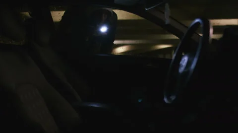 Thief searches inside a car with a torch looking for valuables Stock Footage 68089284