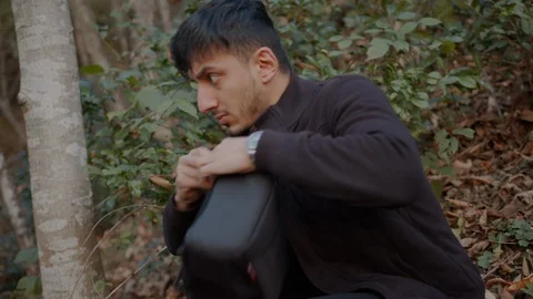 A thief stealing a bag and checking it in the woods. Vídeos de archivo 121772869