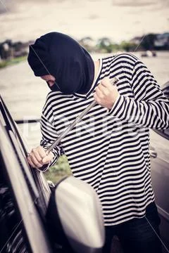 Thief is trying to steal the car at the public parking Stock Photos