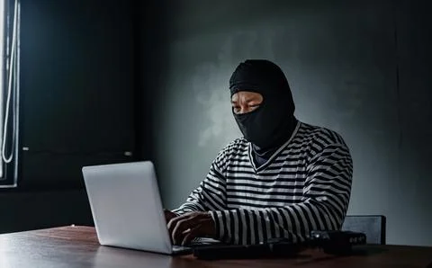 Thief use computer for theft. Hacker stealing data from a laptop concept for  Foto stock
